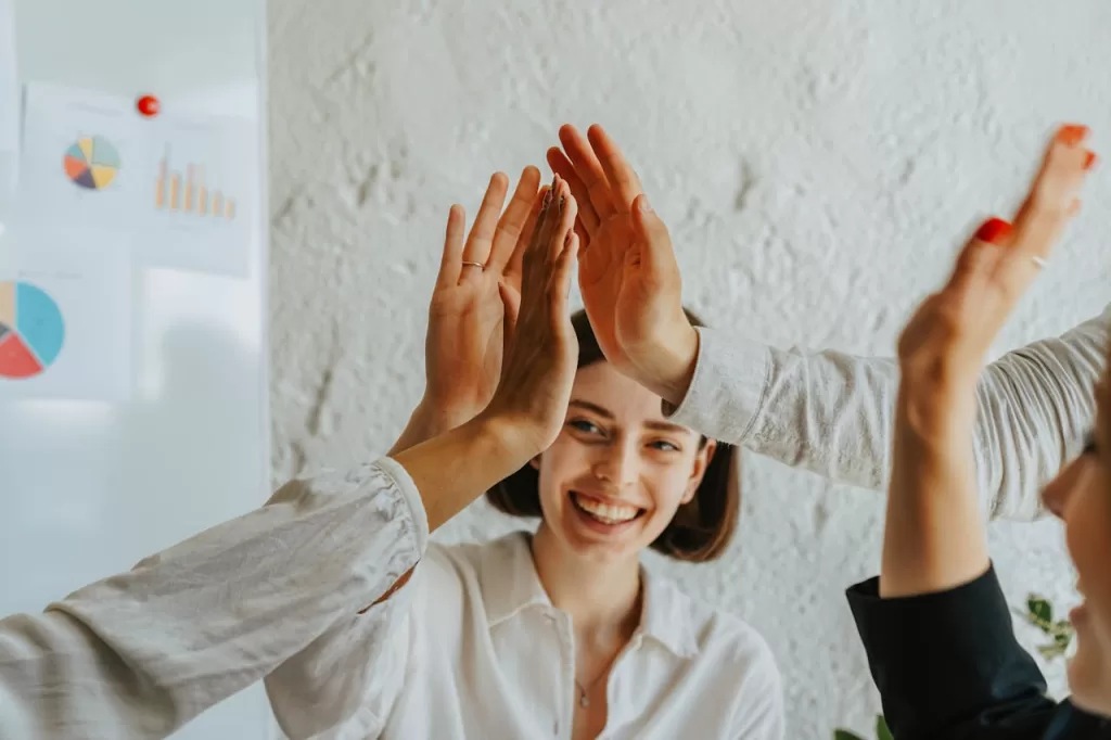 happy office workers high fiving